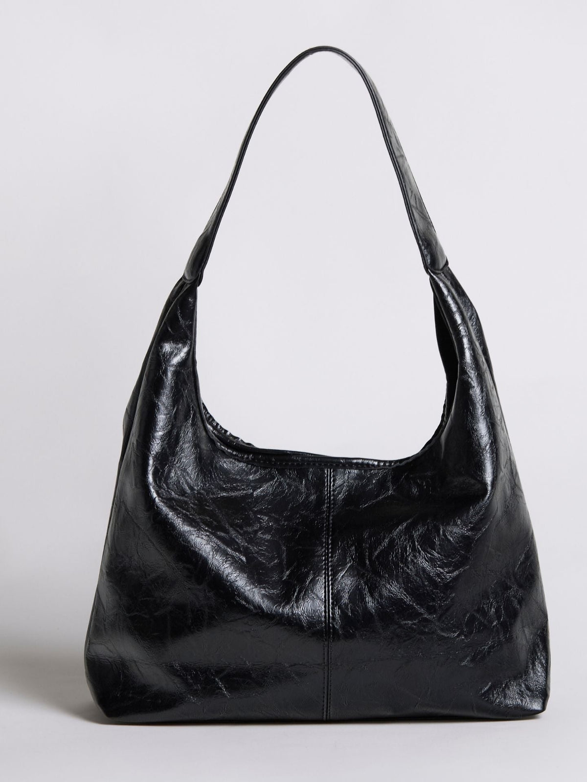 Black distressed vegan leather tote bag with wide handles and a slouchy silhouette.