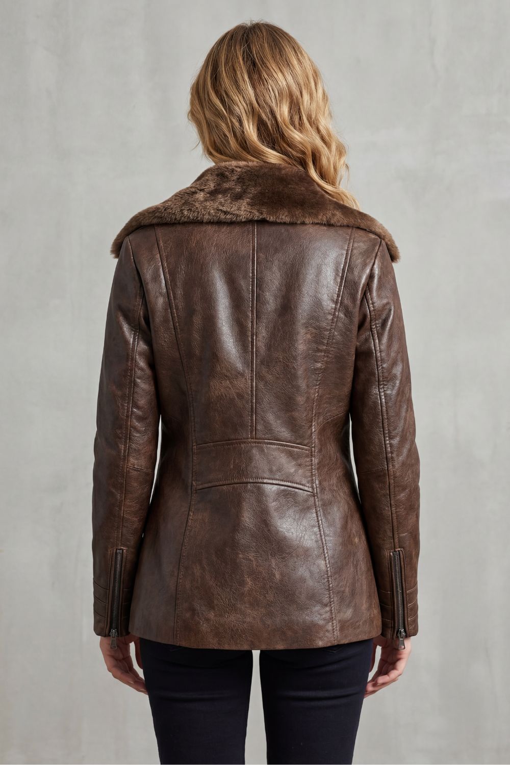 Back view of brown leather jacket with shearling collar and seam details