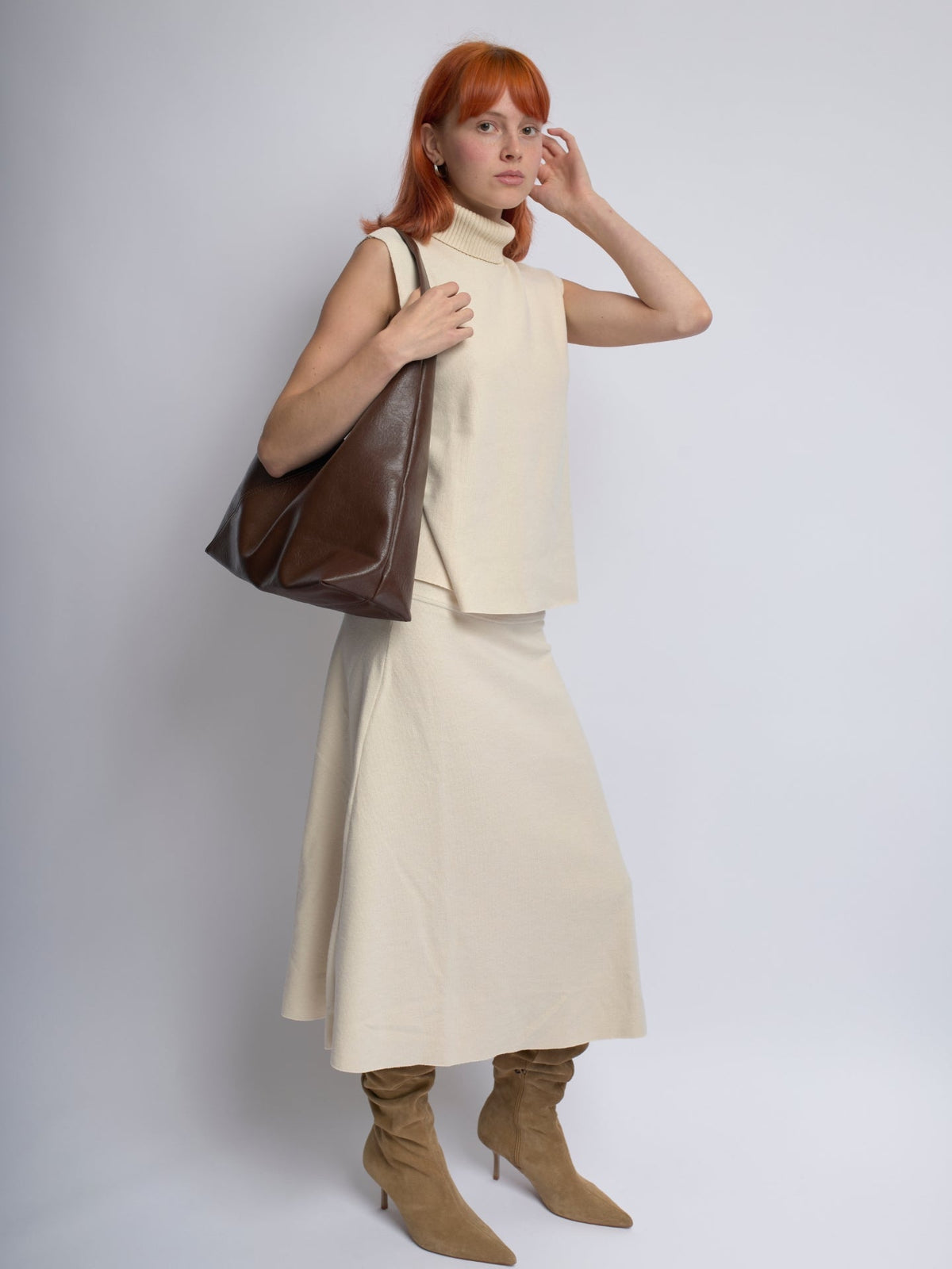 Brown leather shoulder bag with slouchy design and top handle straps