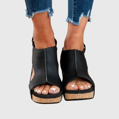 Black orthopedic sandals with open toe, ankle bootie style, and stud accents