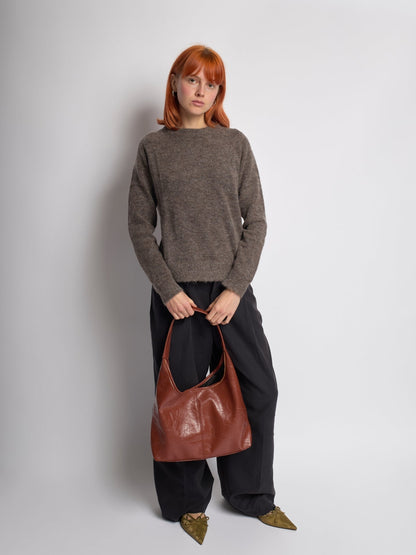 Brown distressed vegan leather tote bag with top handles and roomy open top.