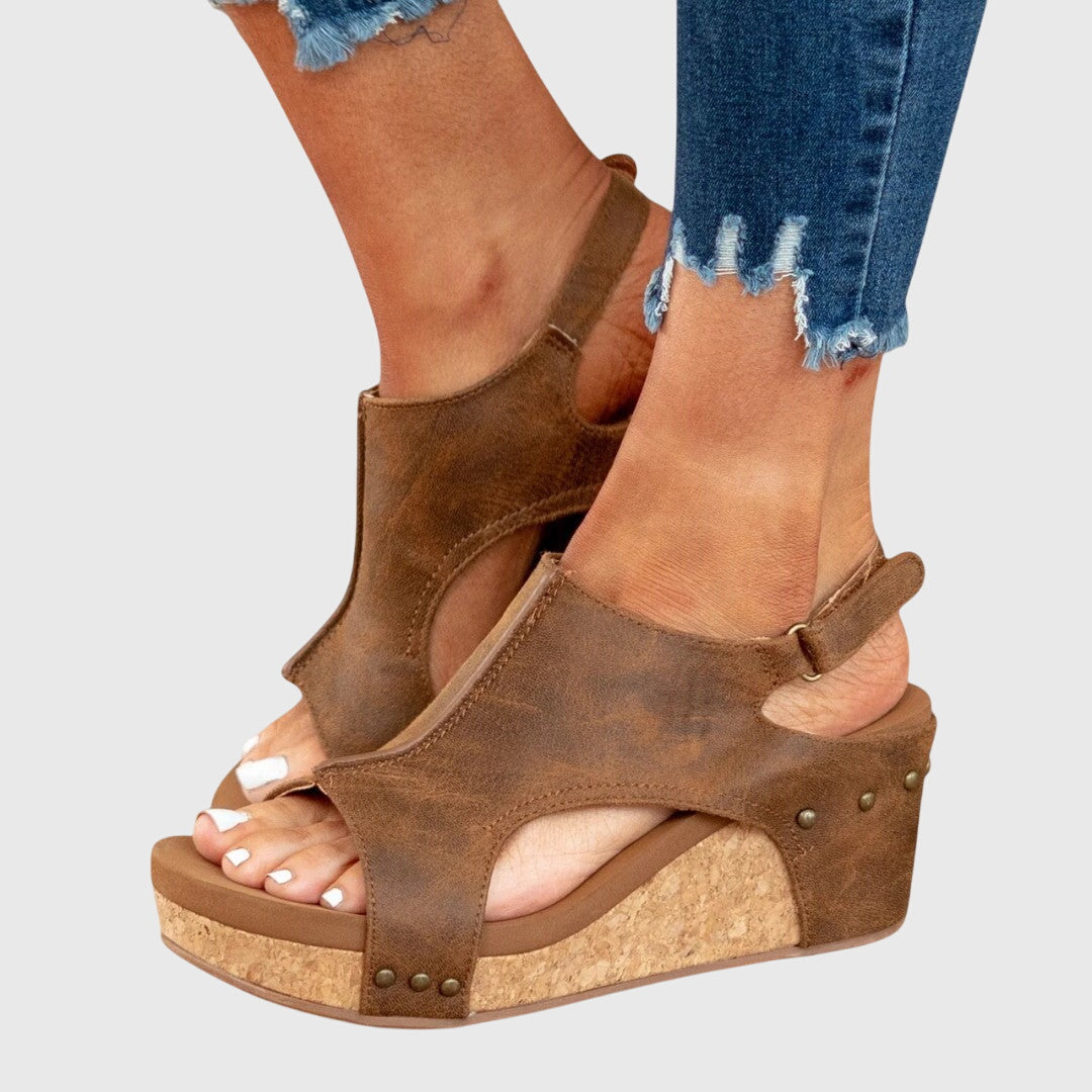 Brown orthopedic wedge sandals with open toe, side straps, and stud accents