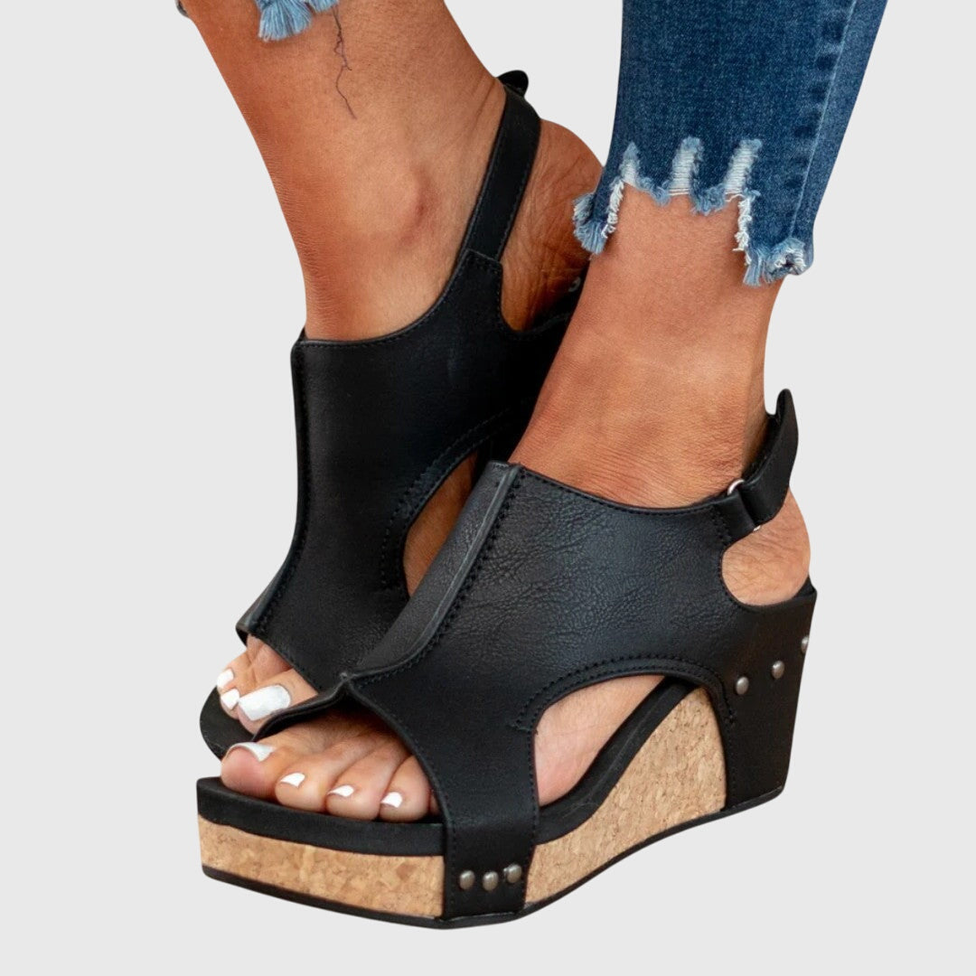 Black orthopedic sandals with crossover straps, cork-look wedge sole, side stud detail