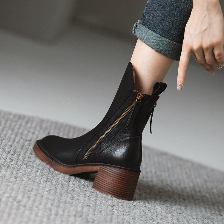 Black ankle boots with side zipper and tassel ties, worn with rolled jeans