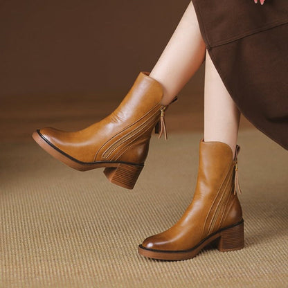 Brown ankle boots on model with side zipper and mid block heel