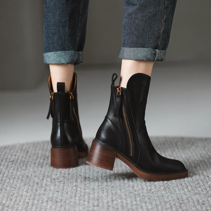 Pair of black ankle boots with side zipper and brown block heel