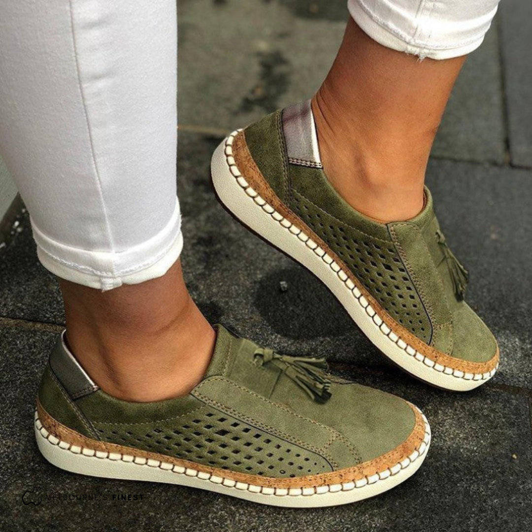 Orthopedic green slip-on shoes with perforated sides, tassel detail, and beige sole