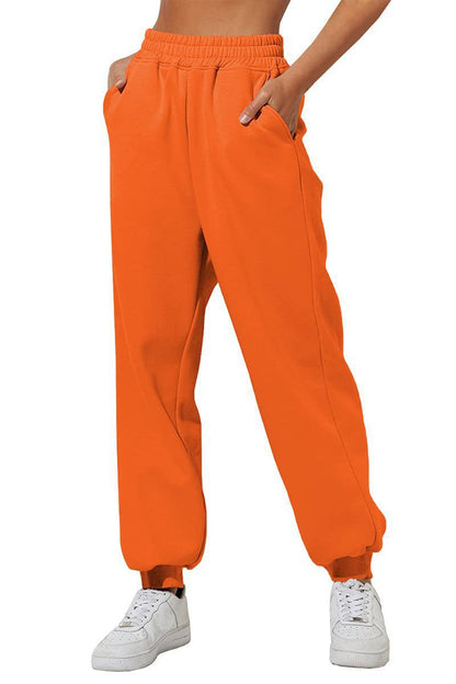 Bright orange sweatpants joggers with elastic waist and relaxed tapered legs.