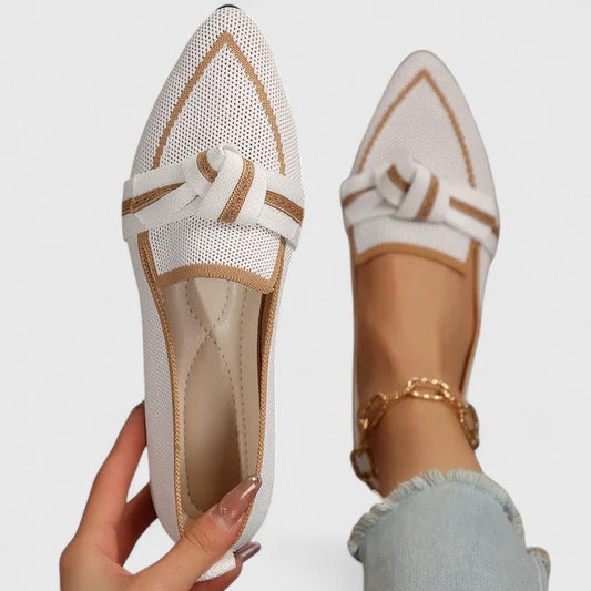 White orthopedic loafers with tan edging, lace bow and textured fabric upper.