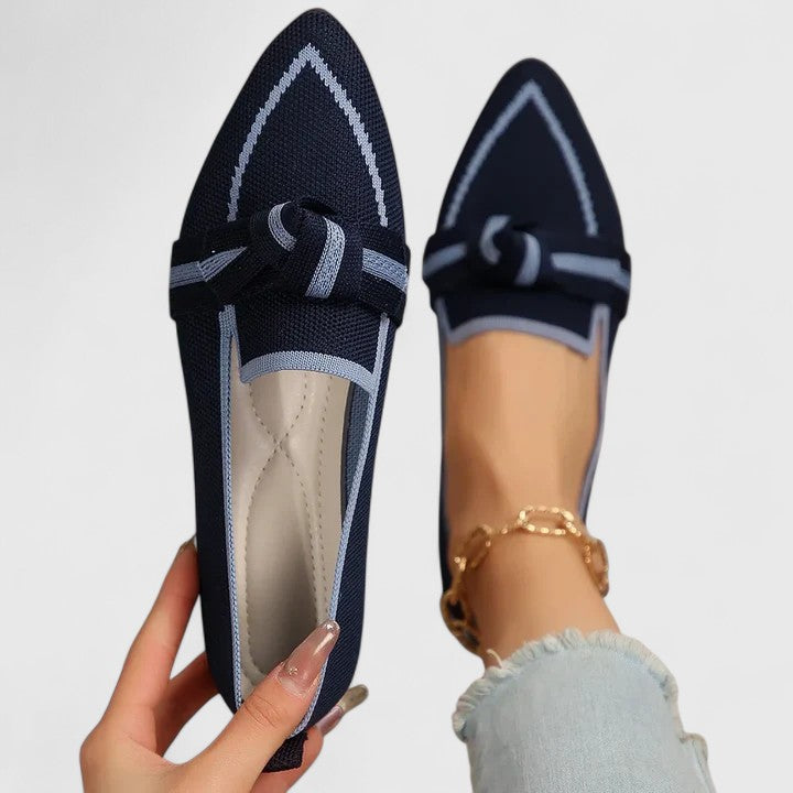 Navy orthopedic loafers with light piping, lace bow and textured knit upper.