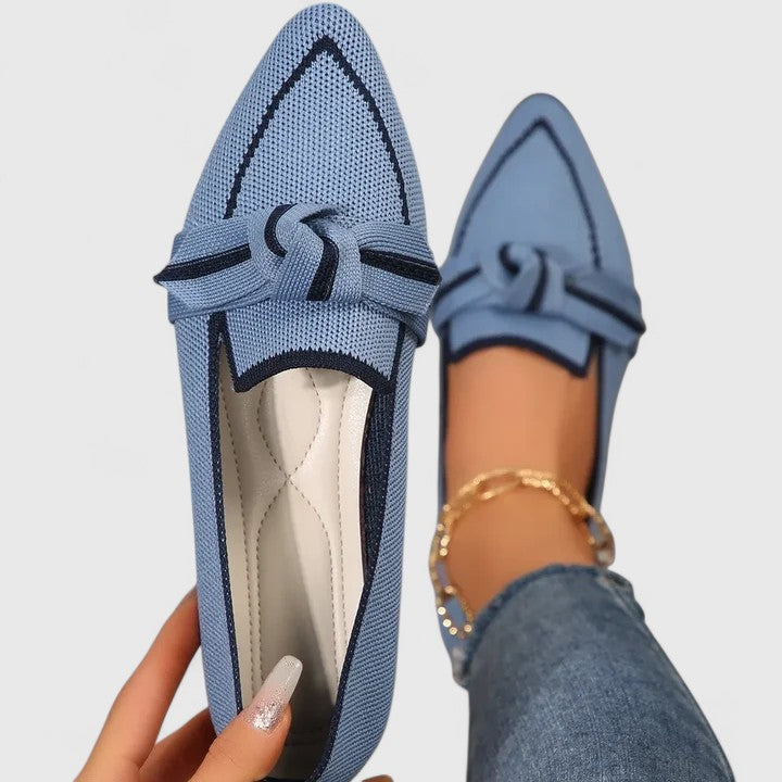 Light blue orthopedic loafers with black trim, lace bow and textured knit upper.