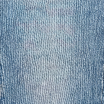 Light blue denim fabric close-up with fine woven texture and seam line