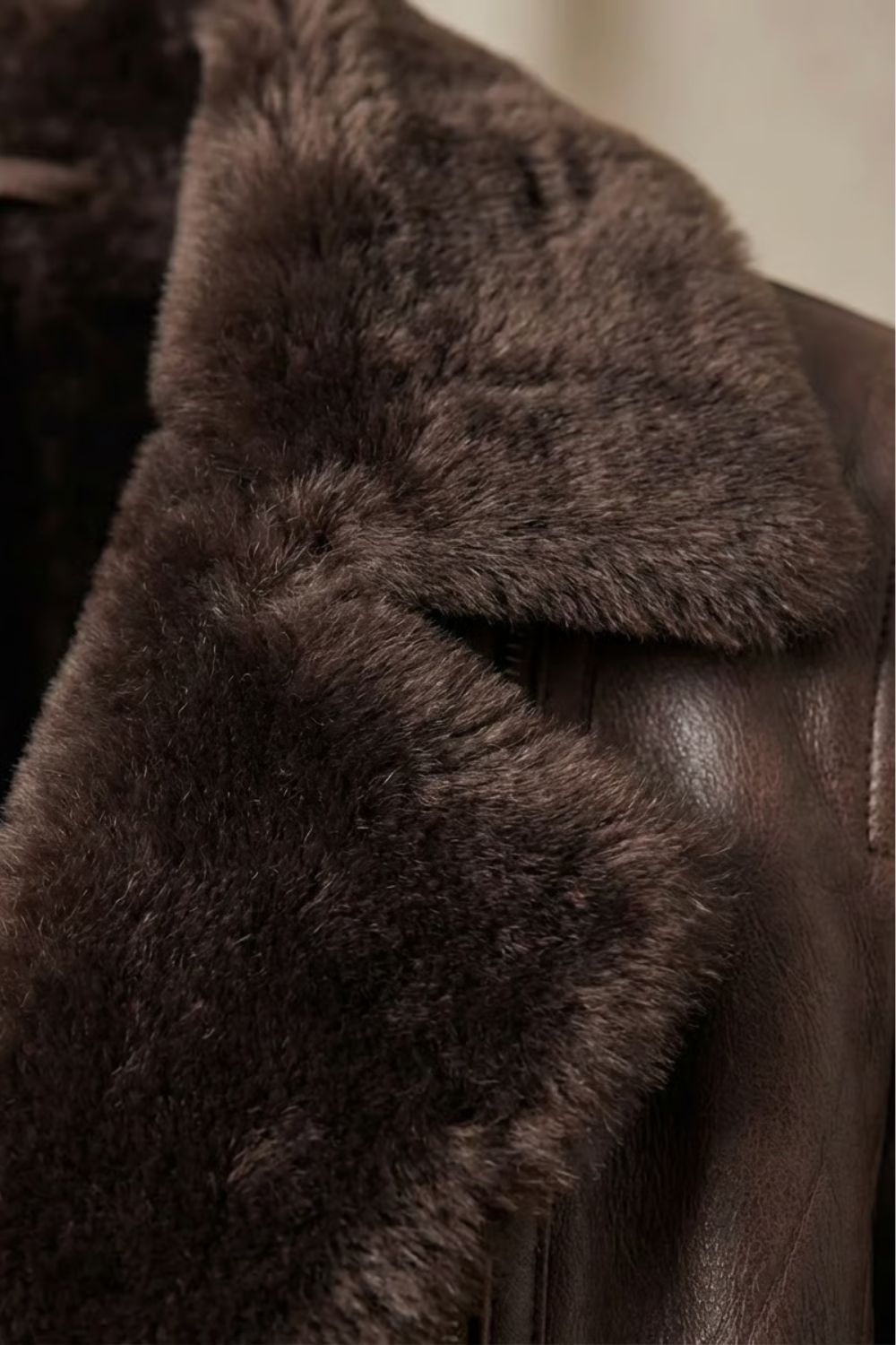 Close-up of brown leather jacket shearling trim on shoulder and collar