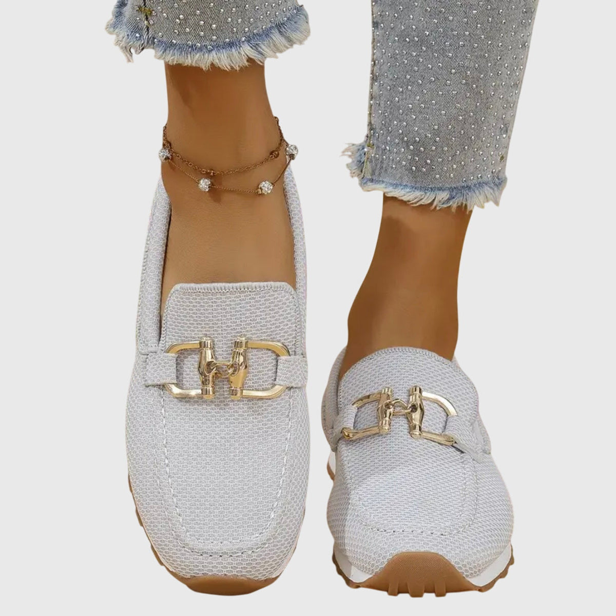 White textured slip-on loafers with gold buckle detail and thick cushioned sole