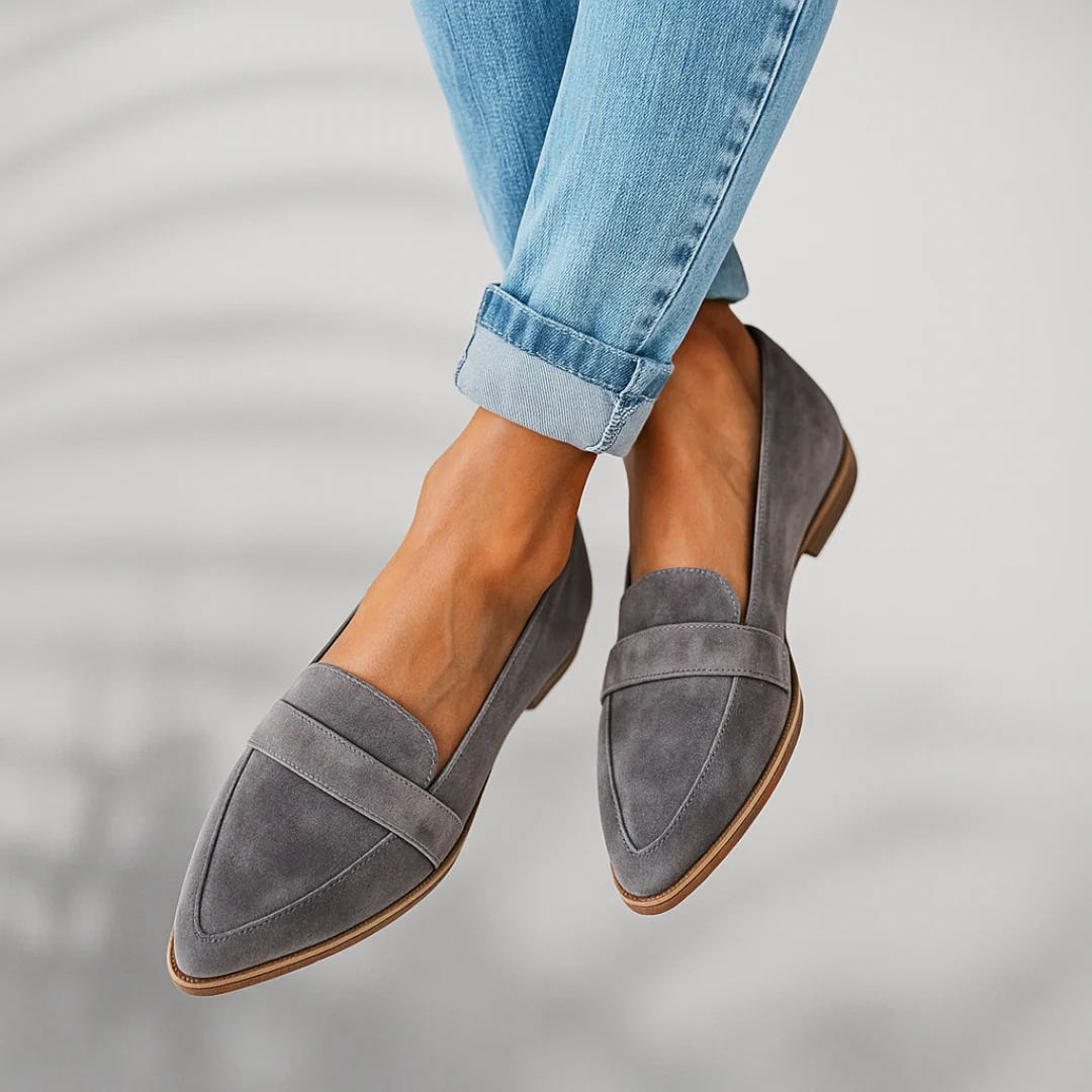 Grey suede slip-on loafers, side view, stitched seam and brown sole